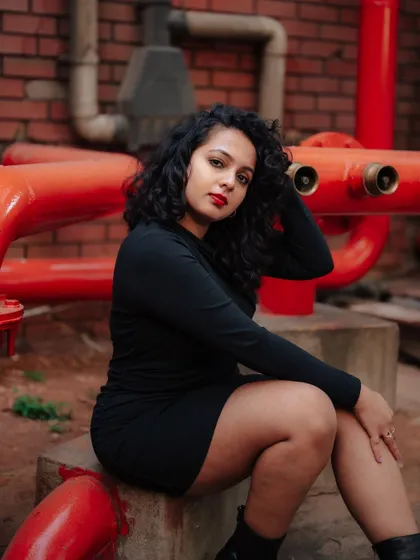 A duplicate of image 388, this portrait uses the contrast of a black dress against red pipes for a striking industrial fashion shot.