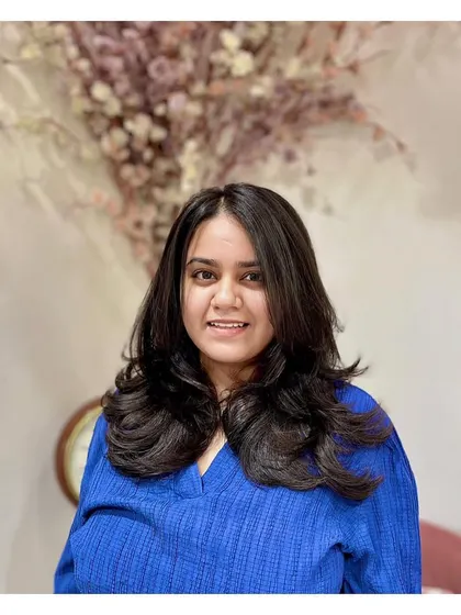 The client looking pleased with her new layer cut. The style is flattering and gives her hair a healthy, voluminous appearance.