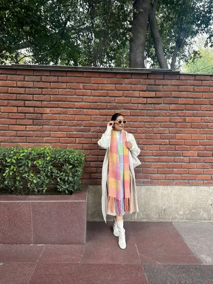 This look proves that you can stay warm and be stylish. The layers provide coziness, while the white boots and pastel scarf keep it looking fresh.