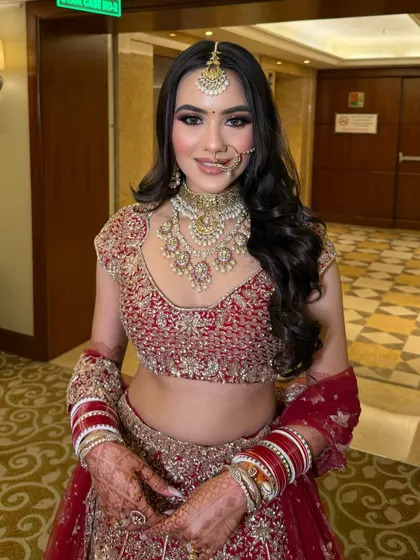 A portrait capturing her happy glow. You can see the detailed henna on her hands and the way the makeup highlights her features without overpowering them. It's all about feeling like the best version of yourself.