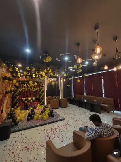 A wider view of the lounge decorated for a birthday, showing the extensive balloon arrangements.