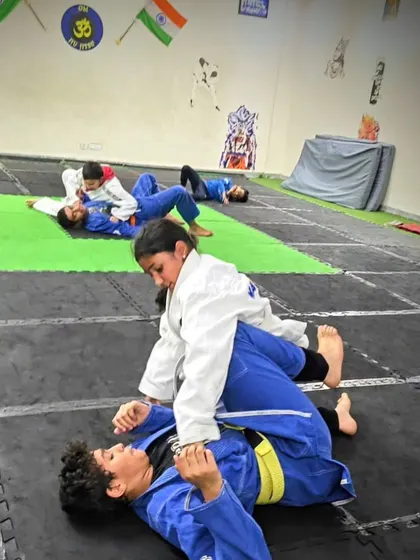 This is where the "gentle art" of Brazilian Jiu-Jitsu begins. A young student learns to control her opponent from the mount position, a foundational skill in grappling that teaches leverage over strength.