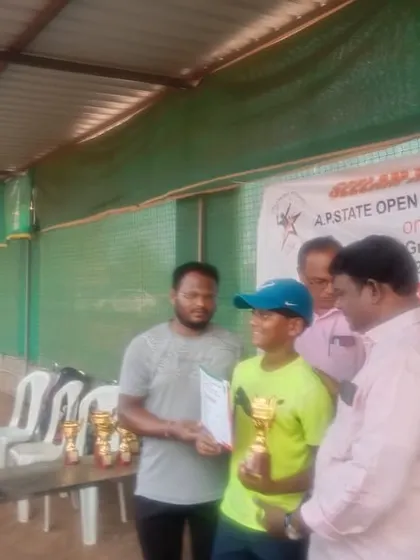 Krish Yadlapalli receiving one of his four trophies from a single state tournament, a testament to his versatility and stamina across different age categories.