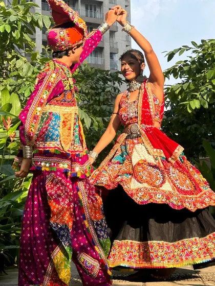 A dynamic dance pose showing the beautiful flare of the woman's lehenga and the traditional cut of the man's kediyu.