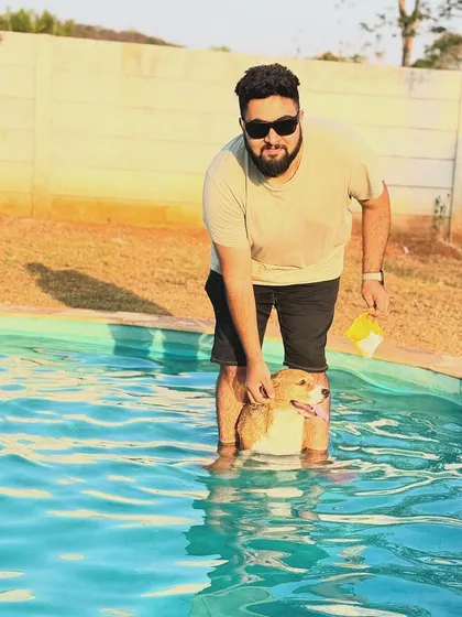 This dog looks completely relaxed getting some encouragement from his dad in the water.