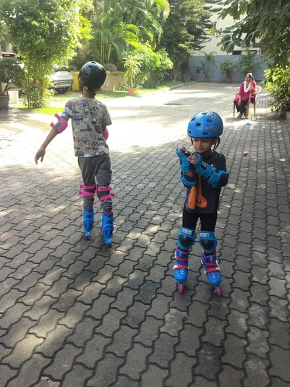 Two young boys get steady on their rollerblades. We ensure every child is properly fitted with helmets and pads before starting any lesson, because safety is our top priority.