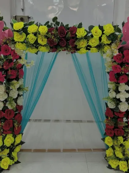 A vibrant and playful floral arch, this piece uses a bright color palette to create a fun and festive atmosphere.
