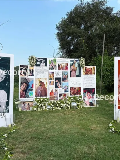 A wide view of the entire outdoor proposal setup, showing how the different photo panels create a journey through the couple's relationship.