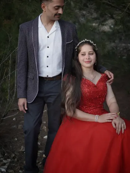 A close up of a couple during their photoshoot. The client wears our sequined red ball gown with a delicate tiara.