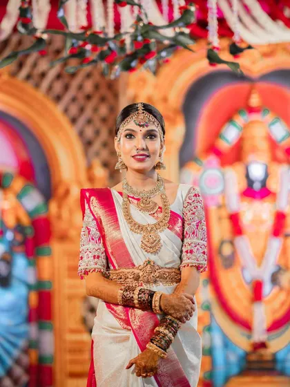 This is the quintessential South Indian bridal look I love to create. For this bride's Muhurtham, we chose a flawless base that lasts through all the ceremonies, paired with classic eye makeup and a bold lip to complement her stunning white and pink Kanchipuram saree.