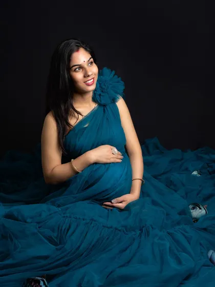 Surrounded by the flowing fabric of her gown, this pose creates a sense of being enveloped in a soft, dreamy cloud. It’s a beautiful way to highlight the baby bump.