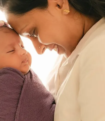 A beautiful, smiling moment between a mother and her newborn baby.