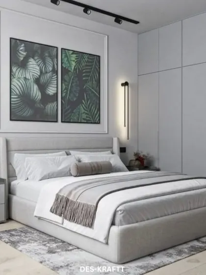 This shot focuses on the floor-to-ceiling grey wardrobes and modern wall sconces, demonstrating our approach to creating storage that is both ample and aesthetically pleasing.
