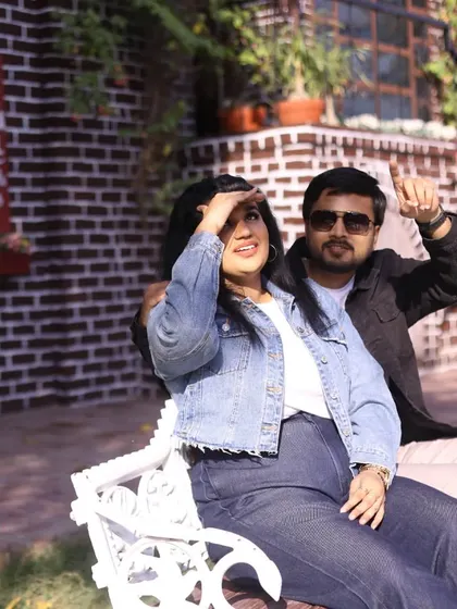 A fun, casual shot from a pre-wedding session, showing the couple enjoying a sunny day on a park bench.