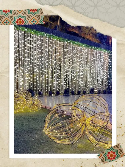 A beautiful decor idea for an outdoor space. I used a curtain of hanging lights as a backdrop and placed large, spherical props with fairy lights inside to add dimension and visual interest.