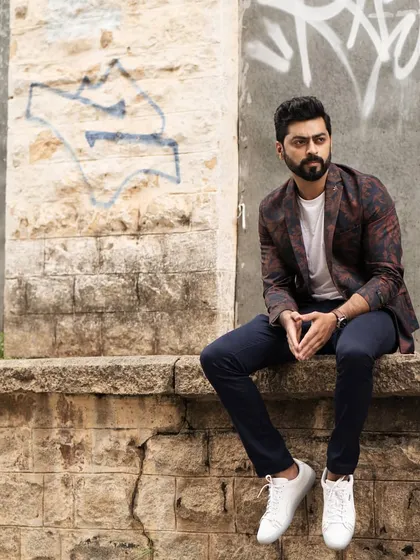 A full-body shot of Tarak Ponnappa in an urban setting, showcasing his style against a graffiti wall. This demonstrates how we can use different angles and compositions in one location.