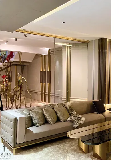 Gold accents and tufted details on the sofa add a touch of classic glamour to this contemporary lounge. We placed a unique brass sculpture in the background to serve as a conversational art piece.