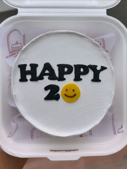 A minimalist bento cake for a 20th birthday, simply saying "Happy 20" with a smiley face.
