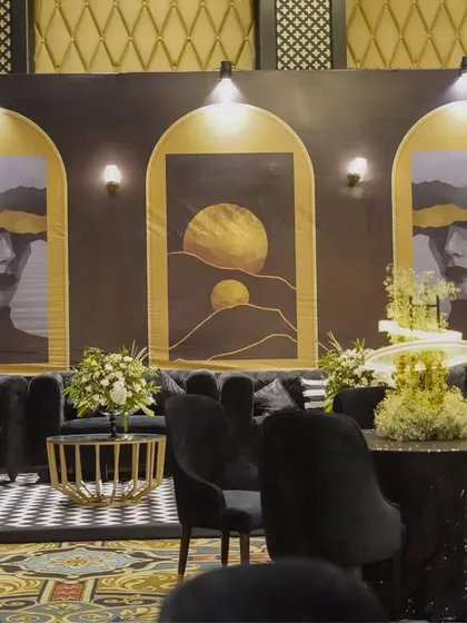 Another view of the lounge, showing the black and white checkered rug, sequined tabletops, and the striking abstract art backdrop, all contributing to the chic and modern vibe.