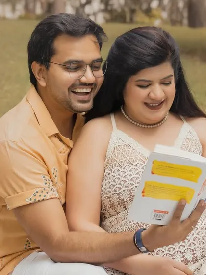 A sweet, candid moment of a couple reading a book together during their outdoor boho session. These relaxed interactions make for the most authentic and memorable photos.
