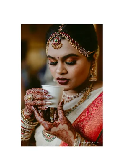 A South Indian bride taking a moment to enjoy her filter coffee. It's these small, personal moments that add so much character to a wedding album.