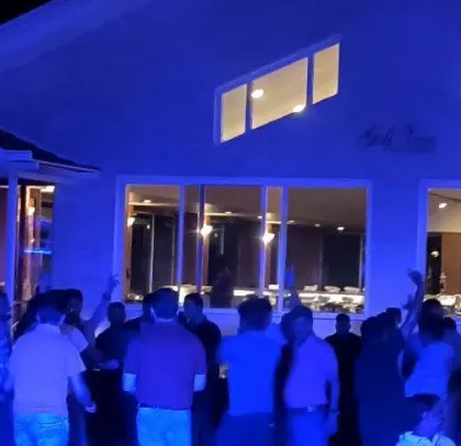 The venue is washed in blue light, creating a cool and modern party atmosphere.