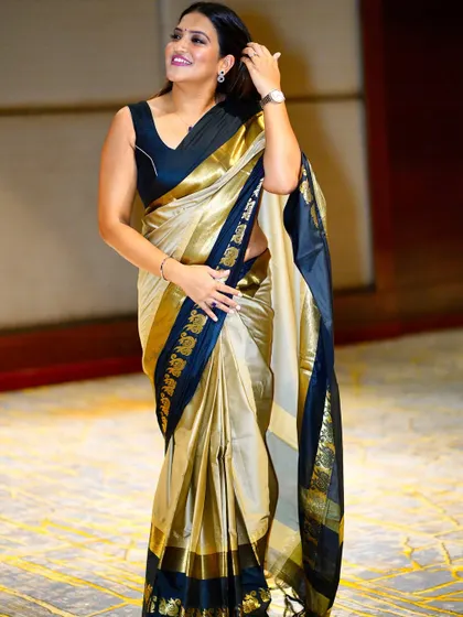 A candid, happy moment captured in this elegant gold and black saree.
