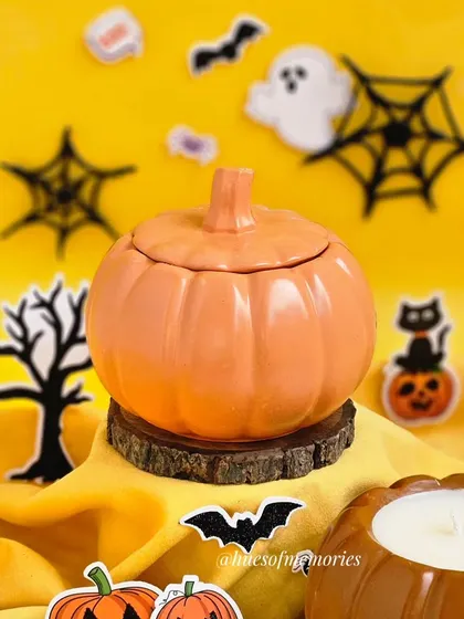 Another view of the pumpkin jar candle, this time with the lid on. The bright orange color makes it a festive centerpiece for any table.