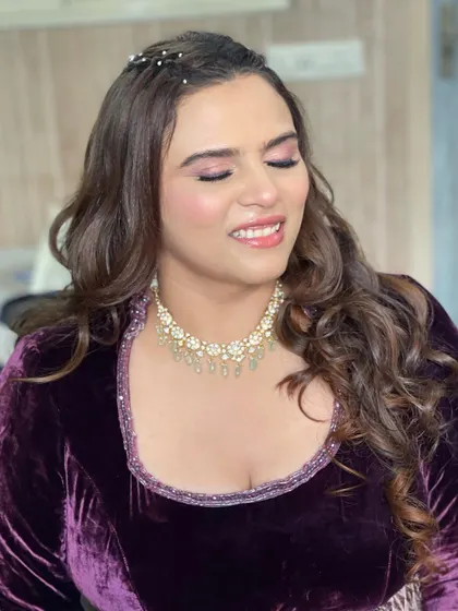 A happy, smiling shot of the groom's sister. The makeup is fresh and pretty, perfect for a day of celebrations.