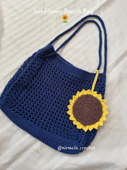 A flat lay of the sunflower beach bag, showing its generous size and the beautiful contrast between the blue mesh and the bright yellow sunflower.