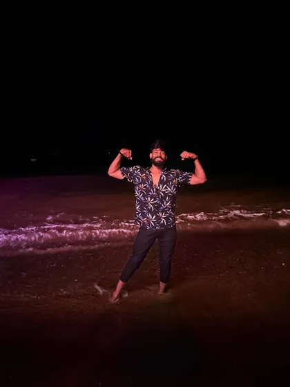 A fun, relaxed bicep pose on the beach at night. Fitness is a lifestyle, even on vacation.