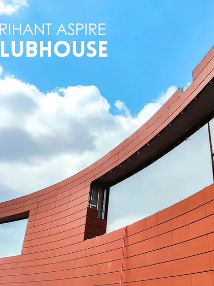 A close-up of the curved terracotta facade of the Arihant Aspire clubhouse during construction.