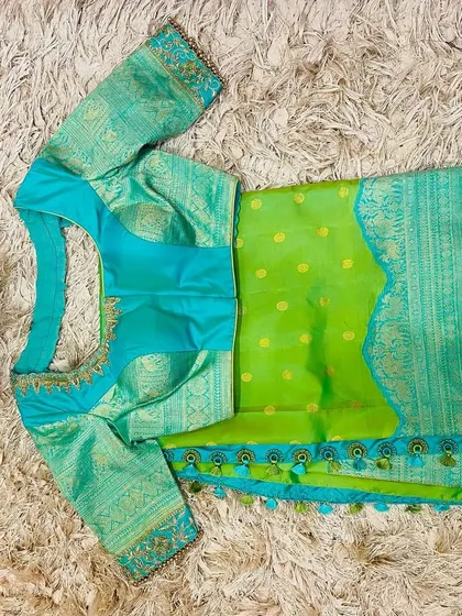 The front of the seafoam blue blouse, showing the padded design and intricate neckline embroidery.