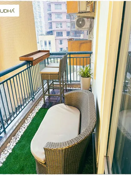 Coordinating furniture is key to a striking balcony. This set of images shows a project where we used matching wicker furniture, including a sofa, chair, table, and bar stools, to create a cohesive and stylish look.
