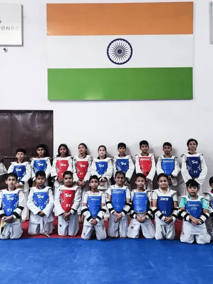 The sub-junior training camp team, ready for their sparring session in front of the Indian flag.