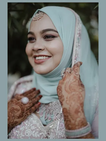 A portrait of the bride with a happy, confident smile, her beautiful henna and elegant outfit perfectly captured.