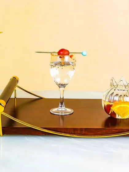 A creative shot of various cocktail glasses and a wooden serving tray. The unusual angles and colorful drinks make for a dynamic and eye-catching beverage photography composition.