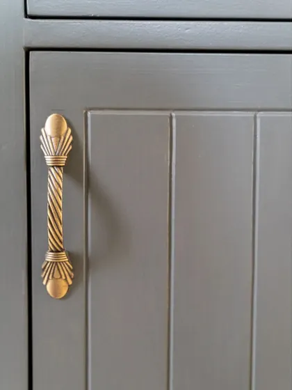 A close-up of the antique-finish hardware on the library unit's cabinets, a small detail that adds immense character.