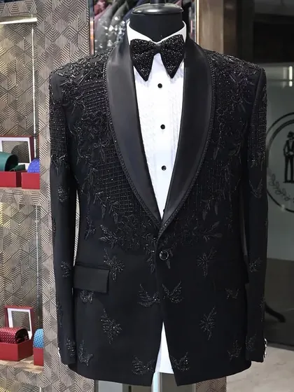A black tuxedo designed with intricate, tonal embroidery. This style is for the man who appreciates subtle luxury, with details that reveal themselves up close.