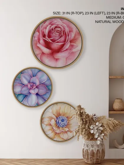 A set of three watercolor flower prints in circular natural wood frames. The vibrant rose, succulent, and daisy designs add a beautiful and artistic touch of nature to the room.