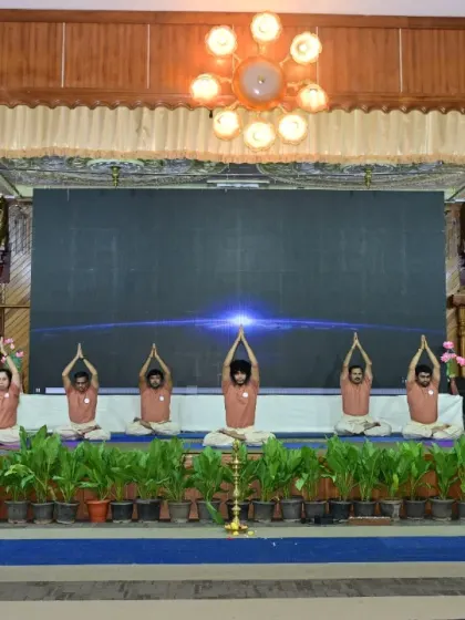 A synchronized starting pose from our students' yogasana demonstration at the Yoga Mitra Mela. The unity and focus here reflect the principles we cultivate in our daily classes.