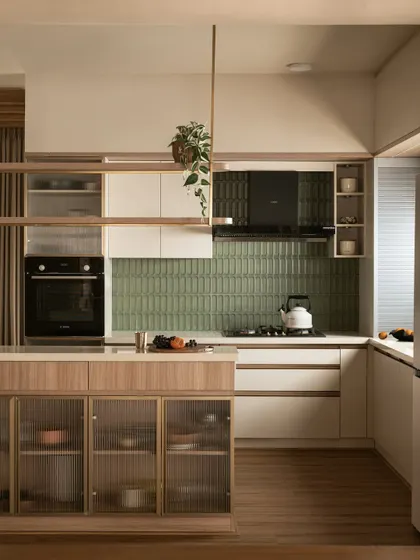 The kitchen in this villa balances bold geometry with natural grace. I used olive green tiles for a pop of color, framed by reeded glass and warm wood cabinetry, with a floating shelf that adds architectural interest.