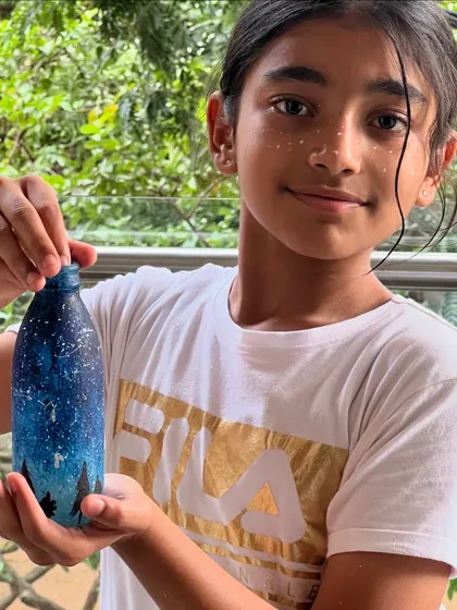 This young artist is so proud of her galaxy-painted bottle, she even gave herself matching starry freckles!