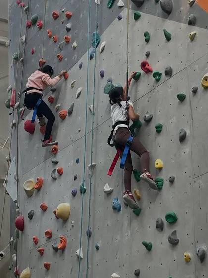 Two young climbers race each other up parallel routes. It's a great way to add a little friendly competition and motivation to any climbing session.