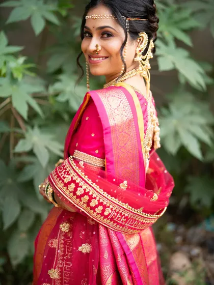 A beautiful profile shot showing the intricate details of her hair and jewellery. The makeup remains soft and elegant, allowing her traditional attire to shine.