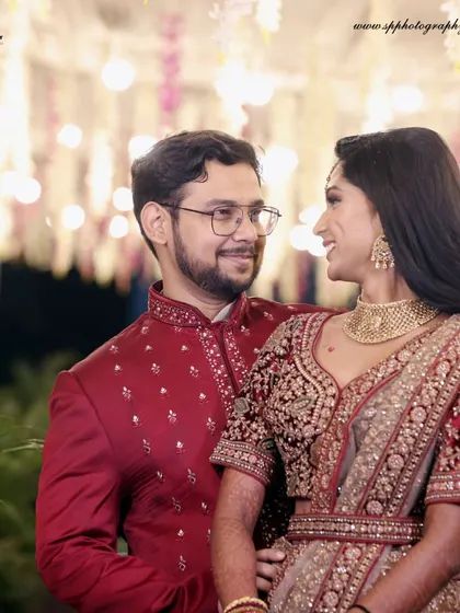 A romantic portrait of the couple against a beautifully lit backdrop. The soft lighting and their close embrace make this a perfect reception photograph.