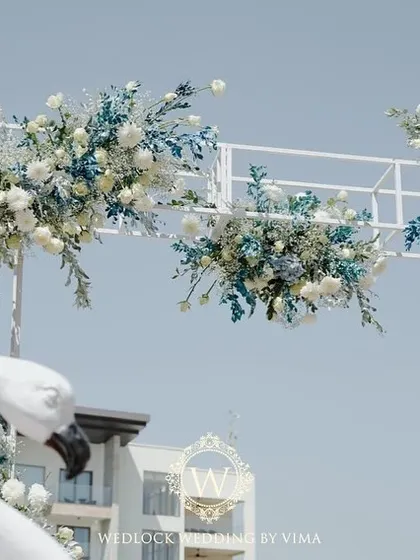 A chic tropical paradise for a brunch pool party. We used elegant white flamingo statues, a floral arch in shades of blue and white, and custom-designed linens to bring the theme to life.