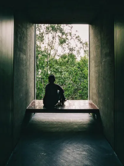 A deeply recessed window frames a view of the landscape, creating a quiet space for contemplation. The thick concrete walls provide thermal mass while the large opening offers a powerful, singular connection to the outdoors.