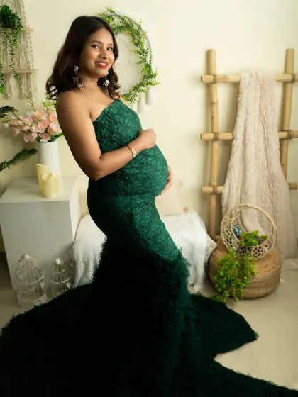 A classic portrait in a textured green gown. The simple, elegant pose highlights the beauty of the dress and the baby bump.