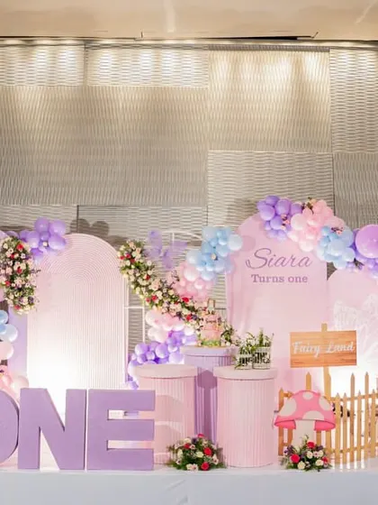 Another angle of the pastel fairy-themed first birthday, showcasing the intricate balloon arch and character cutouts.